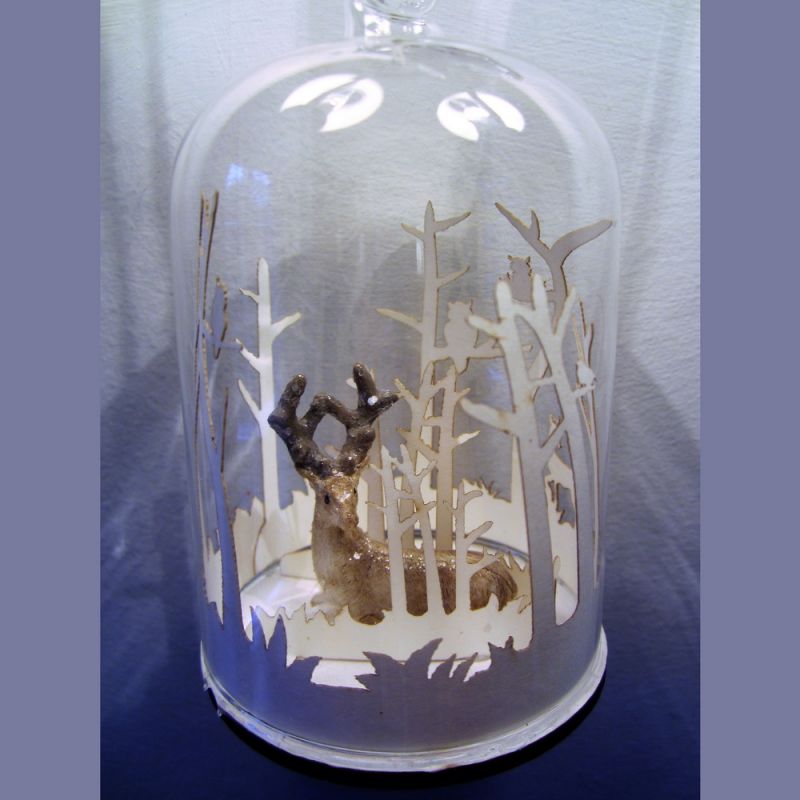 Resting stag in forest snowglobe